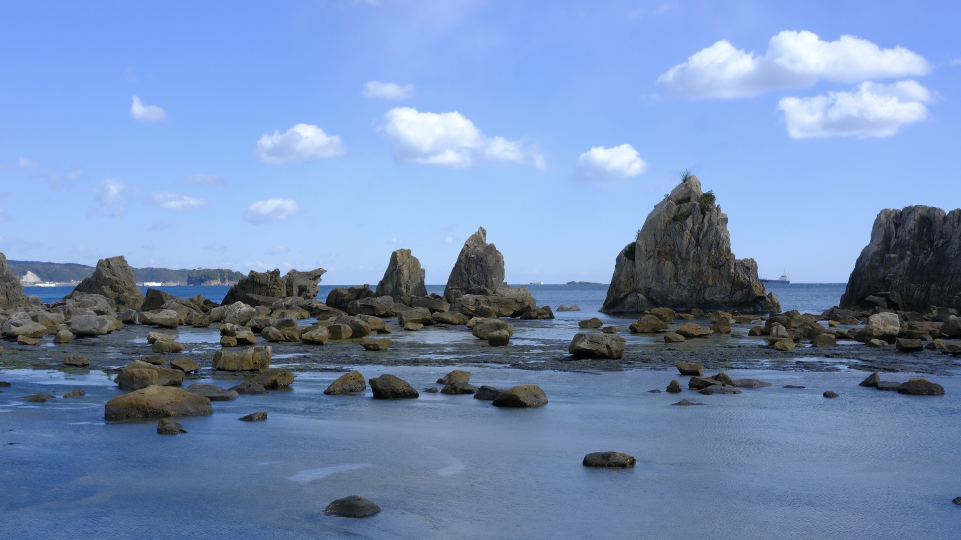 橋杭岩全景,數十根巨岩排列於退潮礁石灘