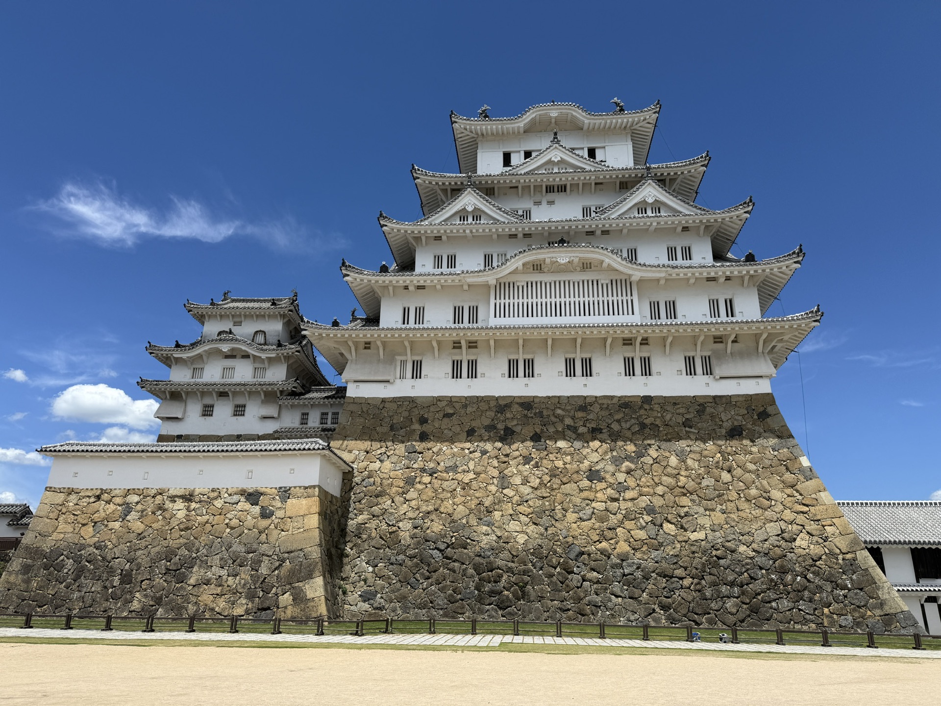從外苑公園遠望姬路城天守閣,白色城樓在綠樹與藍天之間清晰可見