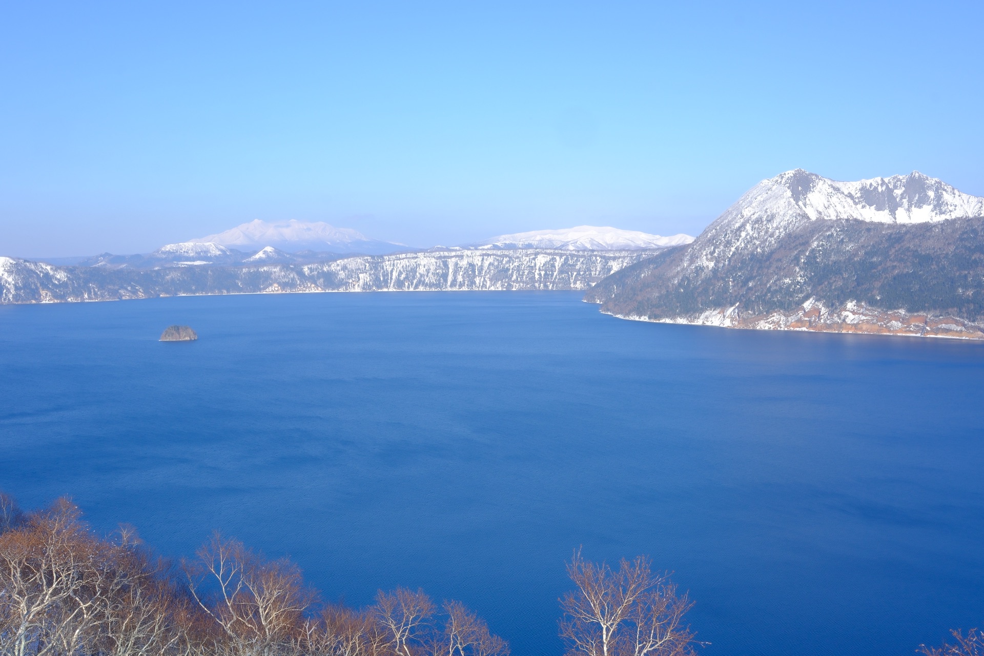 摩周湖全景,深藍色湖水與雪山倒影,中央可見カムイッシュ島
