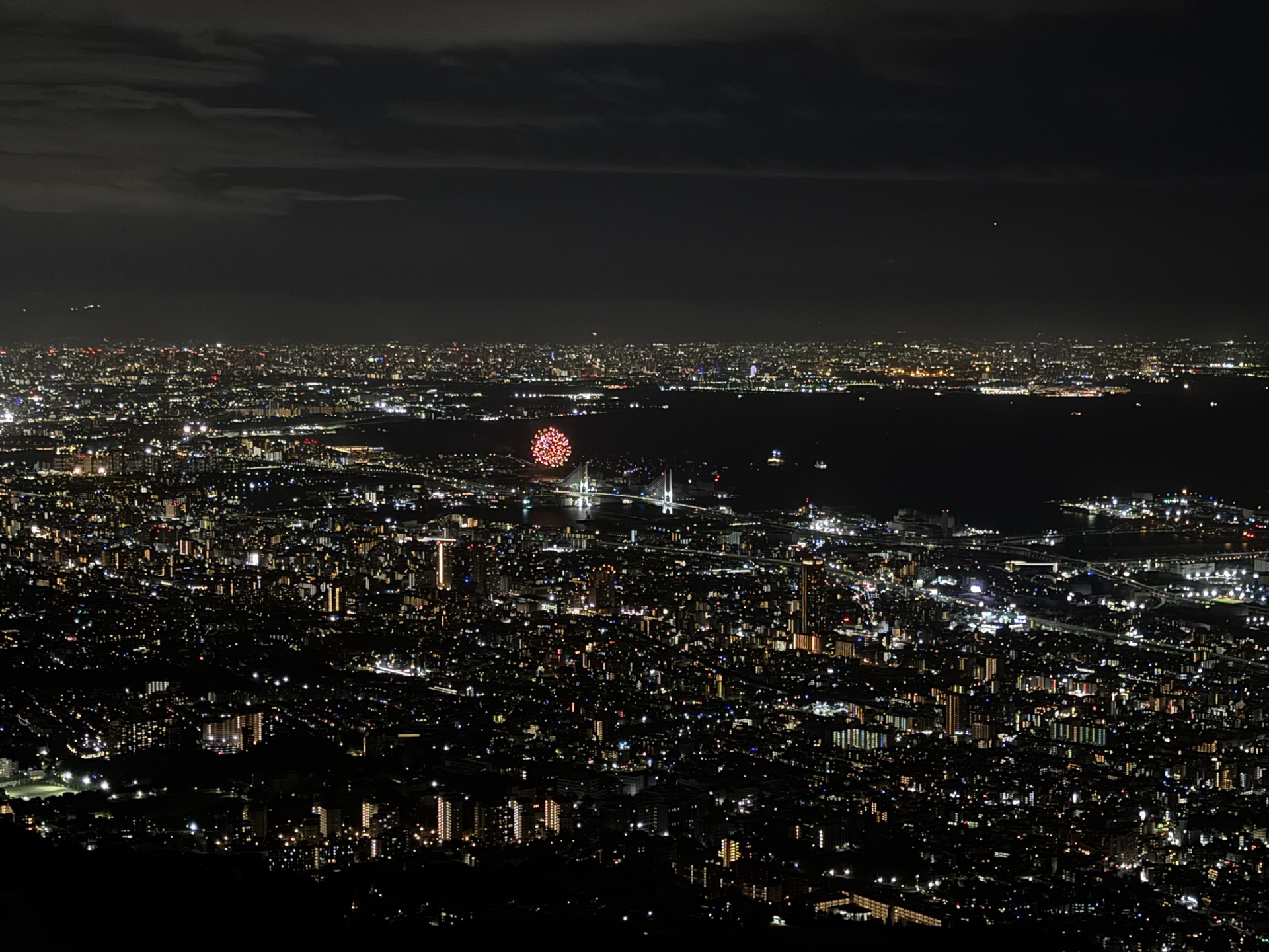 從摩耶山掬星台俯瞰的大阪灣夜景全景，烏雲後方透出城市燈光，視野遼闊