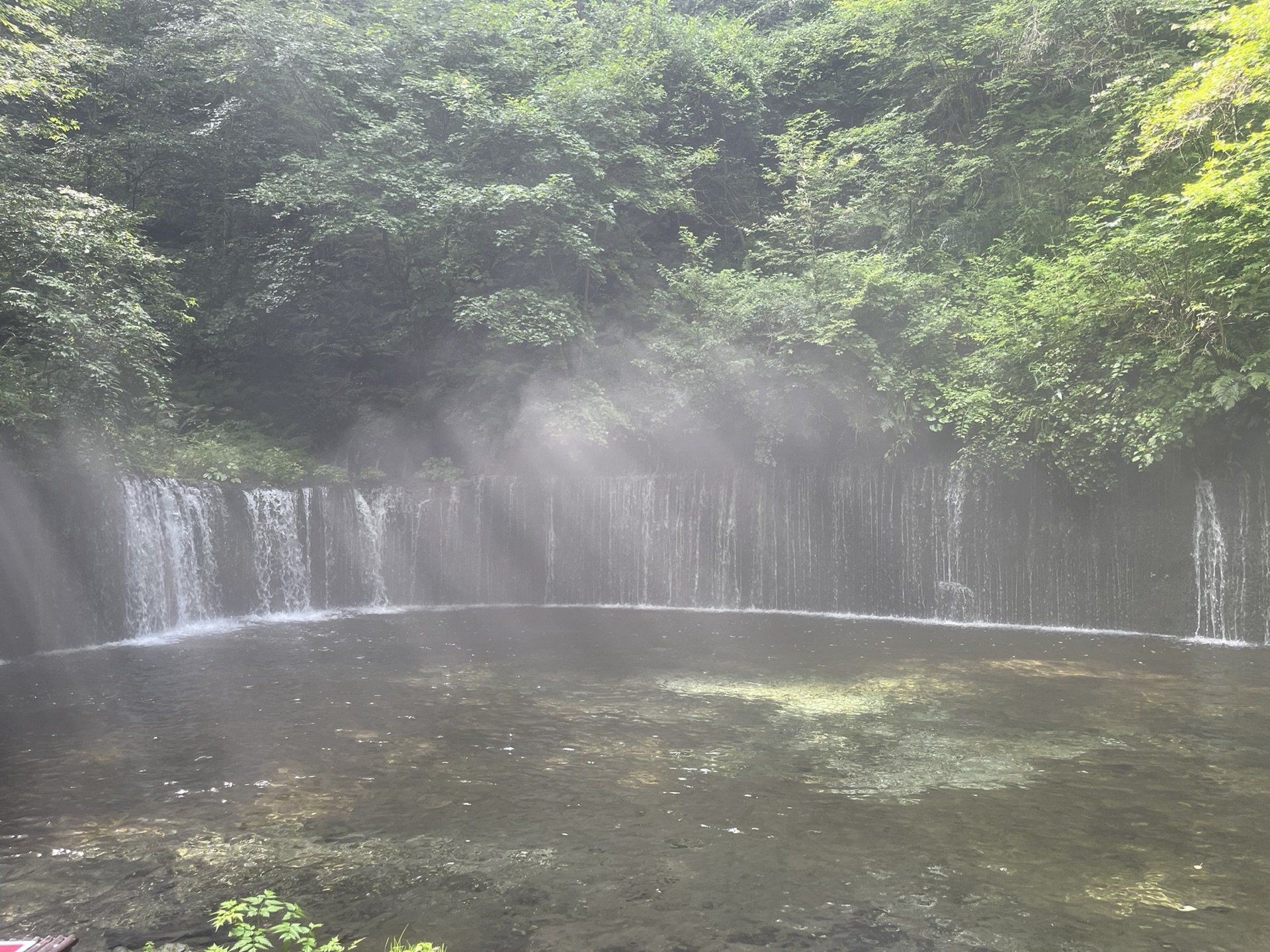 長野縣輕井澤白絲瀑布,半圓弧形岩壁湧出數十條細流形成水幕,濃霧瀰漫整個瀑布空間